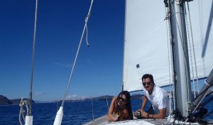 A beautifull couple relaxing on the deck of Barca's sailing boat in Santorini